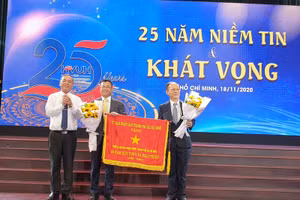 Lãnh đạo Trường ĐH Hùng Vương TP.HCM đón nhận cờ truyền tống của UBND TP.HCM trao tặng