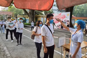 Thí sinh được đo thân nhiệt khi đến trường thi. Ảnh: Tại Điểm thi Trường THPT Chu Văn An (Hà Nội).