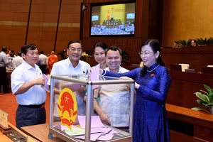 Các đại biểu bỏ phiếu miễn nhiệm các ủy viên Ủy ban Thường vụ Quốc hội.