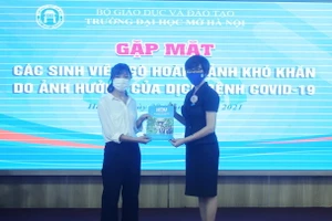 Sinh viên nhận quà hỗ trợ của Trường ĐH Mở Hà Nội từ Phó Hiệu trưởng Nguyễn Minh Phương. Ảnh: NTCC