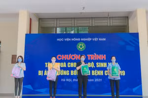 TS Vũ Ngọc Huyên Phó Giám đốc Học viện Nông nghiệp Việt Nam trao các suất quà cho cán bộ và sinh viên Học viện.