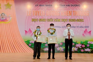 Thầy giáo Lê Thanh Bình (ngoài cùng bên phải) và em Đào Duy Anh (ở giữa) được UBND tỉnh Hải Dương vinh danh, khen thưởng. Ảnh: NVCC