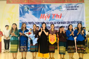 Bà Nguyễn Thị Lài, Phó Trưởng Ban dân tộc tỉnh Quảng Bình trao cờ lưu niệm cho đơn vị đạt giải nhất tại hội thi.