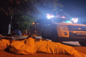 Hình ảnh 2 cán bộ y tế tham gia dập dịch Covid-19 mặc bộ đồ bảo hộ nằm ngủ trên vỉa hè để lấy sức khiến nhiều người xót xa.