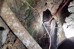 Lực lượng chức năng tiến hành tìm kiếm, đưa thi thể cô gái tử vong dưới hang sâu.