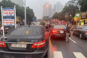 Hai chiếc xe ô tô biển giống nhau lưu thông trên phố.