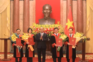 Chủ tịch nước Nguyễn Xuân Phúc trao quyết định bổ nhiệm và tặng hoa chúc mừng 4 tân thẩm phán TAND Tối cao. Ảnh: H. Vũ.