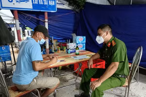 Cơ quan chức năng làm việc với nhóm người có hành vi dùng giấy xét nghiệm Covid-19 giả để qua chốt kiểm soát dịch. Ảnh: Công an Hải Dương.