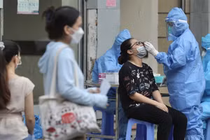 Nhân viên y tế lấy mẫu cho người dân bên ngoài cổng Bệnh viện Việt Đức.