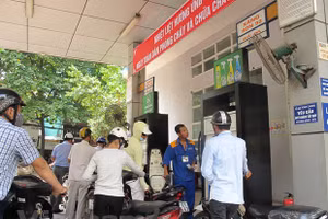 Nhân viên Petrolimex đang bán xăng cho khách hàng. (Ảnh: Đức Duy/Vietnam+).