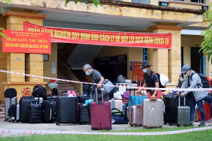 Công dân hoàn thành thời gian cách ly vận chuyển đồ đặc cá nhân để trở về địa phương. (Ảnh: Thanh Hải/TTXVN).