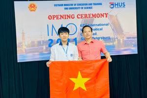 Em Vũ Ngọc Bình (bìa trái) cùng thầy giáo Lê Xuân Đại trong lễ khai mạc IMO 2021