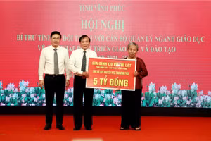 Cụ Vũ Thị Lật trao tượng trưng số tiền ủng hộ cho ông Trần Dũng Long, Chủ tịch Hội – Quỹ Khuyến học tỉnh Vĩnh Phúc. Ảnh Trà Hương