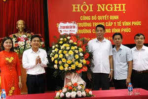 Ông Vũ Việt Văn, Phó Chủ tịch UBND tỉnh Vĩnh Phúc (thứ 2 từ trái qua) tặng hoa chúc mừng BGH Trường Cao đẳng Vĩnh Phúc