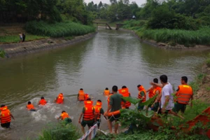 Cán bộ, chiến sĩ Trung tâm Huấn luyện BĐBP tìm kiếm nạn nhân bị đuối nước trên kênh thủy lợi Liễn Sơn. Ảnh: Nguyễn Hào