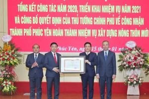 Thừa uỷ quyền của Thủ tướng Chính phủ, Phó Chủ tịch Thường trực UBND tỉnh Vĩnh Phúc Vũ Việt Văn (thứ 2 từ phải qua) trao quyết định công nhận thành phố Phúc Yên hoàn thành nhiệm vụ xây dựng NTM