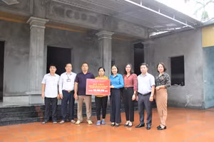 Chủ tịch Công đoàn ngành Giáo dục Vĩnh Phúc (áo xanh) trao tiền hỗ trợ xây nhà cho cô giáo Nguyễn Thị Huyền