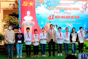 Nhà giáo Lê Văn Sắn - Hiệu trưởng Trường THCS Thổ Tang khen thưởng học sinh dịp 20/11.