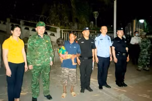 Lực lượng chức năng hai bên bàn giao cháu bé Lý Thị Th. cho gia đình. (Ảnh: Kim Khánh)