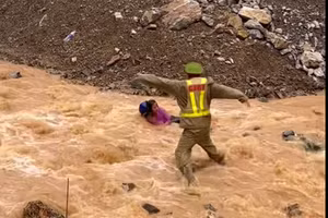 Thượng úy Tường lao ra dòng nước lũ cứu người. Ảnh cắt từ clip.