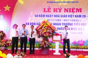 Ông Nguyễn Hữu Nhu - Phó chủ tịch UBND TP Việt Trì (thứ nhất bên phải) tặng hoa chúc mừng và trao Bằng công nhận Trường Tiểu học Tiên Cát đạt Chuẩn Quốc gia mức độ 2 cho lãnh đạo phường Tiên Cát.