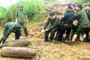 Cán bộ, chiến sỹ Đại đội Trinh sát, Bộ CHQS tỉnh trục vớt bom từ bờ sông Lô lên bờ. Ảnh: Báo Tuyên Quang.