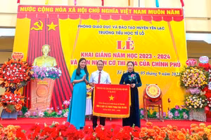 Bà Nguyễn Thị Huấn - Phó Bí thư Thường trực Huyện ủy huyện Yên Lạc (thứ nhất bên phải) trao Cờ thi đua của Chính phủ tặng Trường Tiểu học Tề Lỗ đơn vị xuất sắc trong phong trào thi đua năm học 2021 - 2022.