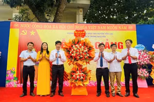 Đại diện Huyện ủy, HĐND, UBND huyện Yên Lạc (bên phải) tặng hoa chúc mừng thầy và trò trường THCS Trung Nguyên nhân dịp khai giảng năm học mới.