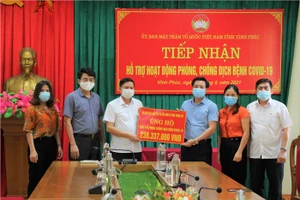 Ông Nguyễn Xuân Viễn - Phó Chủ tịch Ủy ban Mặt trận Tổ quốc tỉnh (thứ ba từ trái sang) tiếp nhận kinh phí hỗ trợ của ngành Giáo dục Vĩnh Phúc.