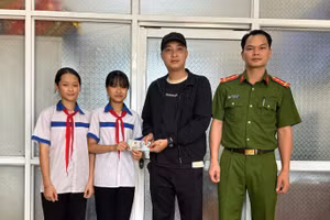 Hai em Như và Nhung trả lại tiền cho người đánh rơi. Ảnh: Công an huyện Hàm Yên