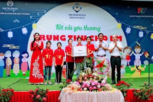 Lãnh đạo Trung tâm Bảo trợ trẻ em mồ côi tàn tật Việt Trì và nhà tài trợ tặng quà cho các em.