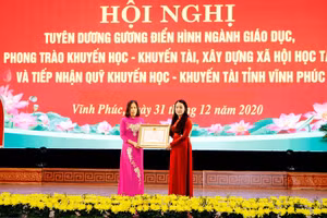 Thừa ủy quyền của Chủ tịch nước, Bí thư Tỉnh ủy Vĩnh Phúc Hoàng Thị Thúy Lan (bìa phải) trao Huân chương Lao động hạng Ba cho nguyên Hiệu trưởng Trường THPT Nguyễn Viết Xuân.