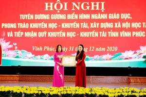 Thừa ủy quyền của Chủ tịch nước, Bí thư Tỉnh ủy Vĩnh Phúc Hoàng Thị Thúy Lan (bìa phải) trao Huân chương Lao động hạng Ba cho nguyên Hiệu trưởng Trường THPT Nguyễn Viết Xuân.