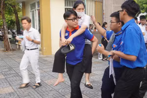 Thí sinh bị thương ở chân được tình nguyện viên cõng vào phòng thi. Ảnh K.C