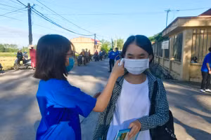 Thanh niên tình nguyện huyện Kinh Môn đo thân nhiệt cho thí sinh tại Hội đồng thi Trường THPT Phúc Thành (Kinh Môn)