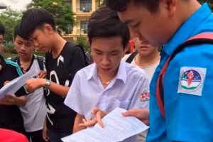 Phạm Vương Minh Quang (áo trắng) trao đổi cùng bạn sau kỳ thi tuyển sinh vào lớp 10. Ảnh: NTCC