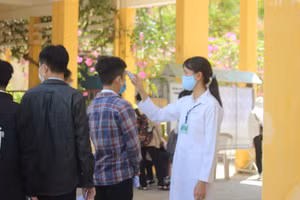 Thí sinh dự thi tốt nghiệp THPT lần 1 ở Quảng Nam được đo thân nhiệt trước khi vào cổng trường thi.