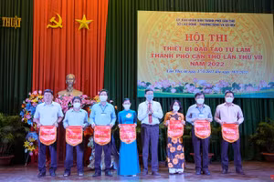 Ông Tiêu Minh Dưỡng, Phó Giám đốc Sở LĐ-TB&XH, Trưởng ban tổ chức hội thi tặng cờ lưu niệm cho các đơn vị tham gia hội thi.