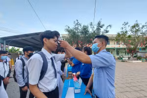 HS Trường THPT Trung An, huyện Cờ Đỏ đo thân nhiệt, khử khuẩn tay trước khi vào trường.