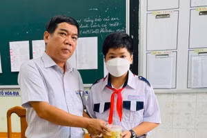 Thầy Lâm Ngọc Thành, Phó Hiệu trưởng Trường THCS Nguyễn Trãi (TP Long Xuyên, tỉnh An Giang) trao phần ăn sáng cho học sinh tại trường