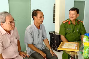 Ông Phạm Văn Diệu (giữa) được công an trao tặng bằng khen vì đã có thành tích trong phong trào Toàn dân tham gia bảo vệ an ninh Tổ quốc .