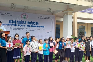 Đại diện Ban Dự án tặng sách cho các em học sinh huyện Tri Tôn.