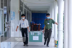 Lực lượng an ninh hỗ trợ vận chuyển bài thi đến khu vực chấm thi.