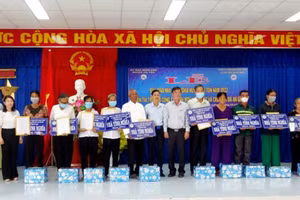 Đại diện lãnh đạo huyện Tri Tôn (tỉnh An Giang) trao tặng bảng biểu trưng nhà tình nghĩa cho 10 gia đình chính sách.