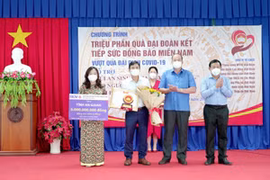 Chủ tịch UBND tỉnh An Giang (người thứ 2 từ phải sang) tặng hoa cho đại diện doanh nghiệp.