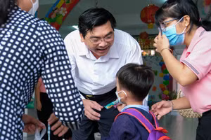 Ông Trần Thanh Bình, Giám đốc Sở GD&ĐT TP Cần Thơ đón và tặng bánh kẹo cho trẻ nhân dịp ngày đầu tựu trường