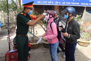Lực lượng bộ đội tại chốt kiểm tra khai báo y tế, đo thân nhiệt và rửa tay (ảnh Cổng TTĐT Cà Mau).