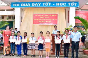 Thầy Trần Kim Cưng (phải) trao khen thưởng cho học trò nhân Ngày Nhà giáo Việt Nam.