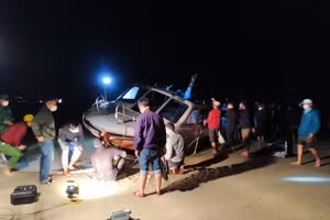 Lực lượng chức năng và người dân trục vớt cano bị nạn. 