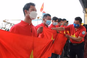 Đại diện Báo Người Lao động trao cờ Tổ quốc cho ngư dân. 